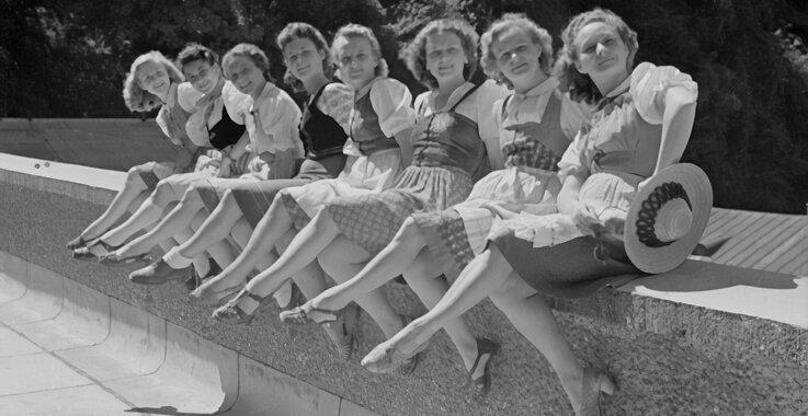 Auf dem schwar-weiß Foto sind junge Damen im sommerlichen Gewand im Sommer zu sehen. 