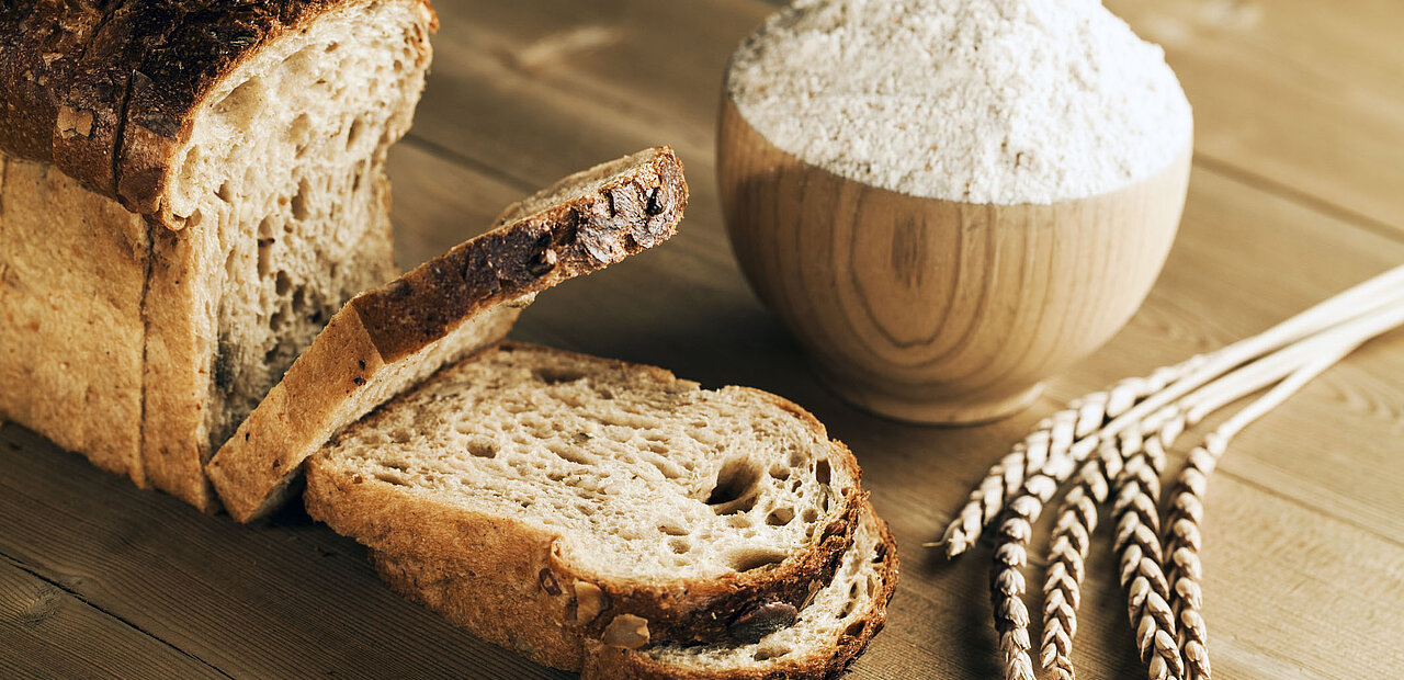 Dinkelbrot und Dinkelmehl liegen auf einem Tisch