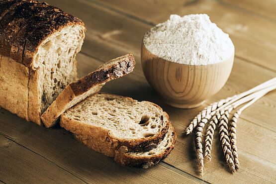 Dinkelbrot und Dinkelmehl liegen auf einem Tisch