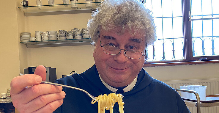 Pater Johannes Paul Abrahamowicz nimmt den ersten Bissen Pasta.