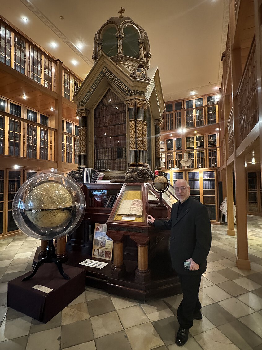 Pater Vahan Hovagimian vor dem Bücherschrank für das Kaiserjubiläum 1898 in der Klosterbibliothek der Mechitaristen in Wien-Neubau. 