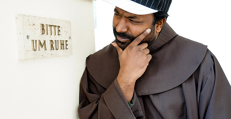 Rappender Franziskaner Manuel Sandesh betrachtet ein Schild