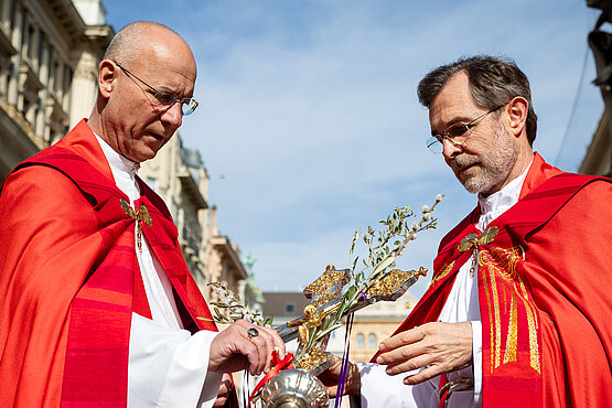 Dompfarrer Toni Faber und Erzbischof Josef Grünwidl (bei Entstehung diese Bildes war er noch Apostolischer Administrator) mit einem Kreuz, welches mit Zweigen und "Palmkatzerln" geschmückt wurde. 