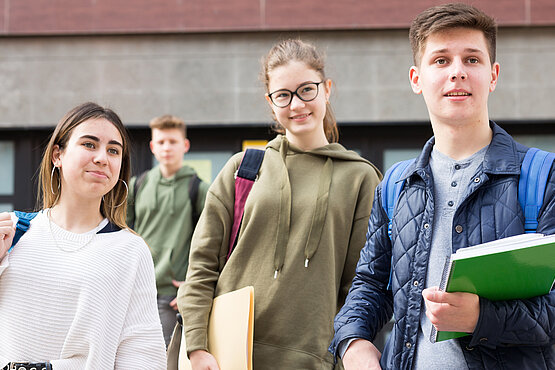 Jugendliche vor einem Schulgebäude