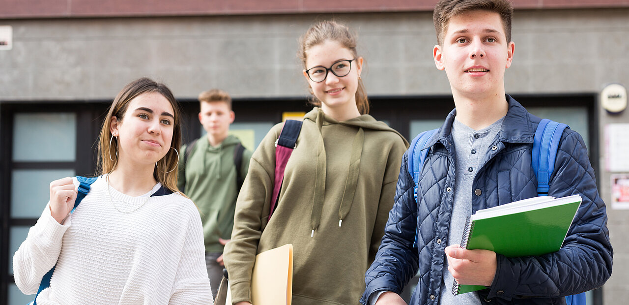 Jugendliche vor einem Schulgebäude