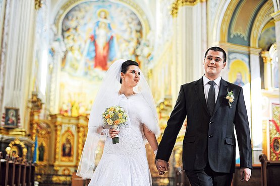 Braut und Bräutigam ziehen zu Hochzeitslied aus der Kirche aus