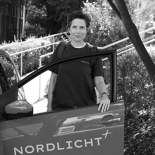 Lisa Haderer steigt in ein Auto ein.