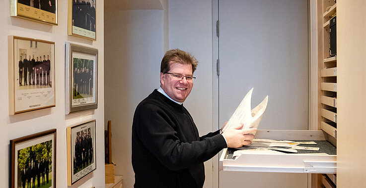 Wolfgang Moser bei der Arbeit, Blätter in der Hand