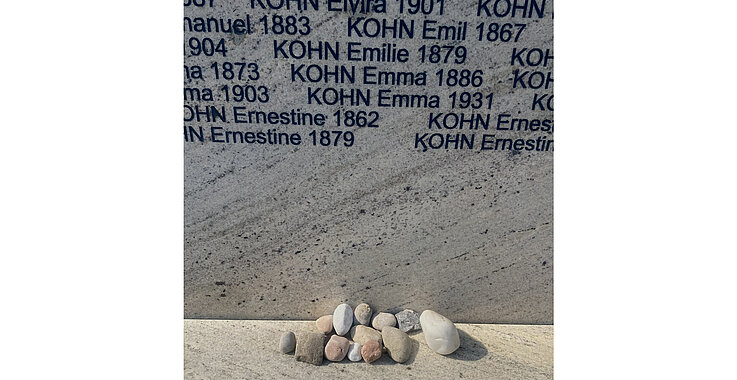 „That makes it real“, sagt ein Teilnehmer, als er diese Steine bei den Namen seiner Angehörigen an der Shoah-Namensmauern-Gedenkstätte niederlegt. 