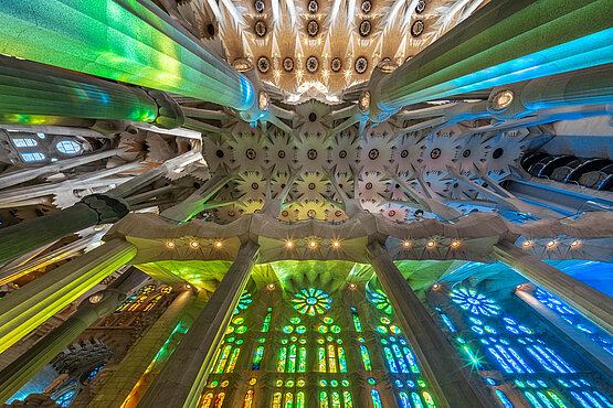 Durch die Kirhenfenster flutet Licht in leuchtendem Rot, Blau, Grün und Gold den Innenraum der Sagrada Família und taucht ihn in eine beinahe himmlische Atmosphäre.