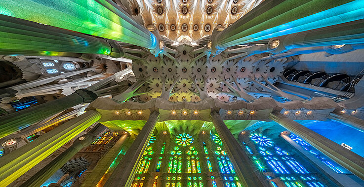 Durch die Kirhenfenster flutet Licht in leuchtendem Rot, Blau, Grün und Gold den Innenraum der Sagrada Família und taucht ihn in eine beinahe himmlische Atmosphäre.